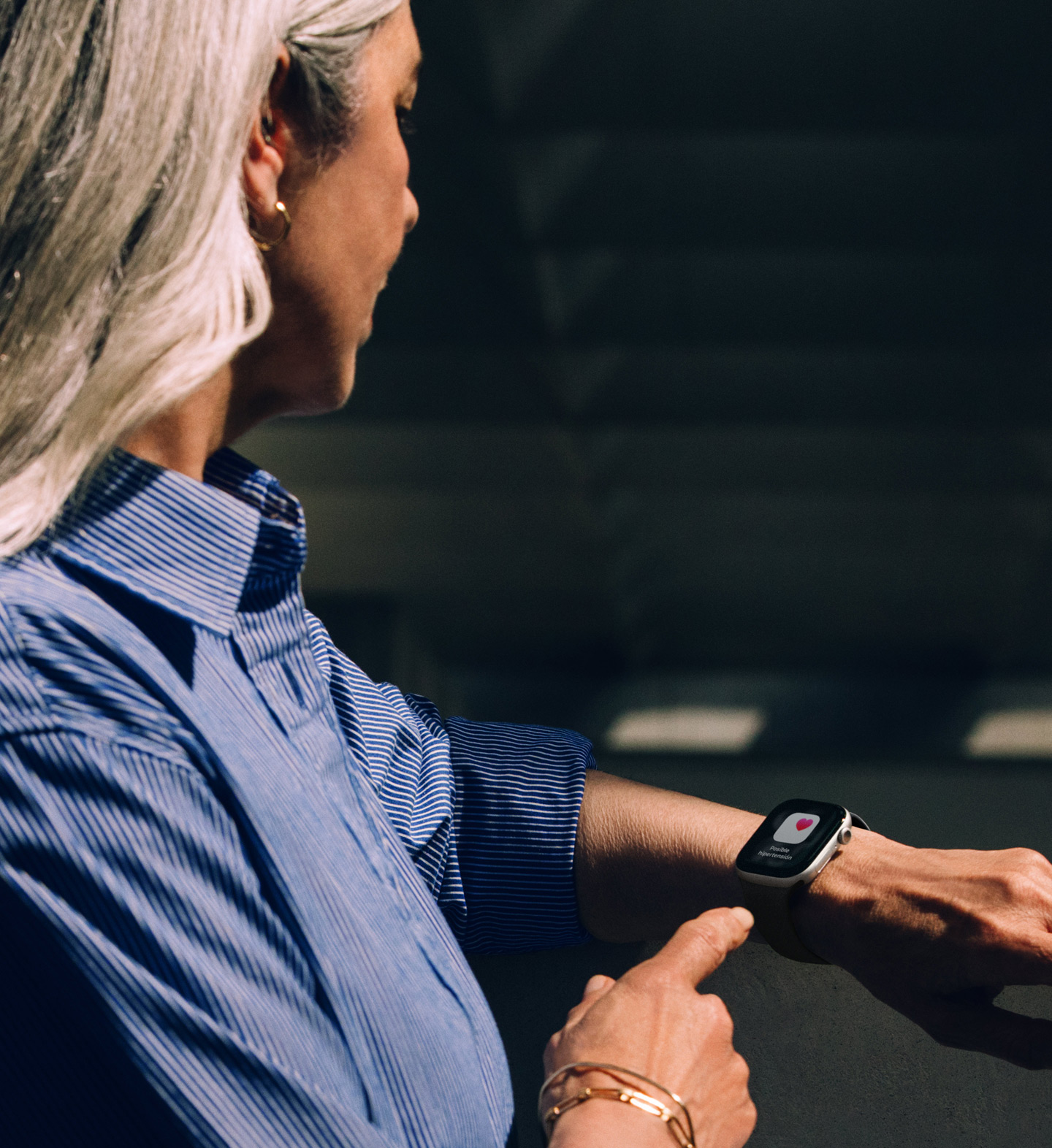 Una persona lee una notificación de posible hipertensión en un Apple Watch Series 11