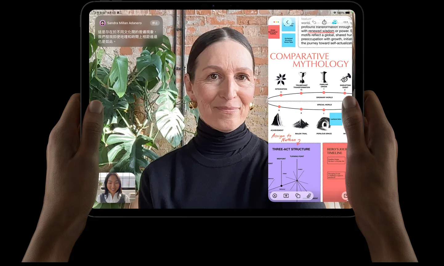 太空黑色 iPad Pro 機身正面，左右手以橫向拿著 iPad Pro，展示圓角設計與黑色顯示器邊框，顯示器展示正在即時翻譯 FaceTime 對話，以及展示 Comparative Mythology 簡報的教育 app，內含文字、圖表與手寫筆記