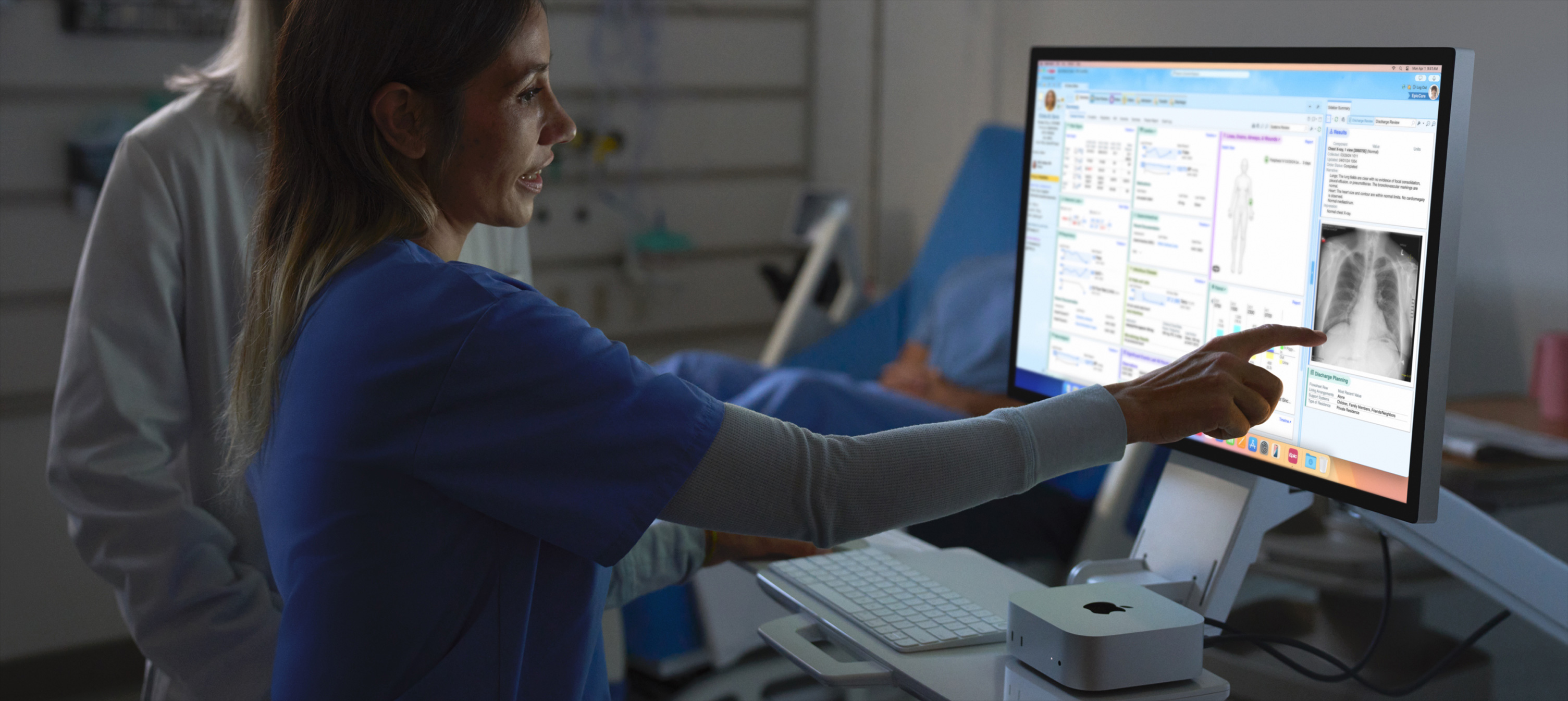 Image of nurse pointing out patient’s X-ray image on iMac.