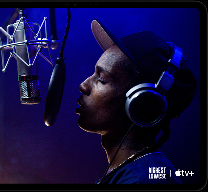 Vooraanzicht van iPad Pro in de kleur spacezwart in horizontale stand, afgeronde hoeken, zwarte rand rond display, op het display wordt een scène uit de Apple TV+-Original-film Highest 2 Lowest afgespeeld met ASAP Rocky als Yung Felon die rapt in een microfoon